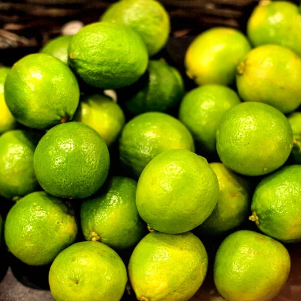 Organic pile of green Limes on a local farmer market. Healthy local food market concept  in vintage hipster style.