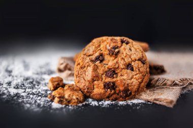 Çikolatalı kurabiye ile koyu arka plan üzerinde metin için yer. Choco cookie siyah arduvaz gemide keten peçete, boşaltmak ile seçici odak