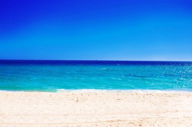 Akdeniz sahil şeridi temiz dalgalı su ile üzerinde güzel deniz manzarası. Yaz paradise Sandy beach adlı mavi gökyüzü ile doğal arka plan olarak güneşli gün