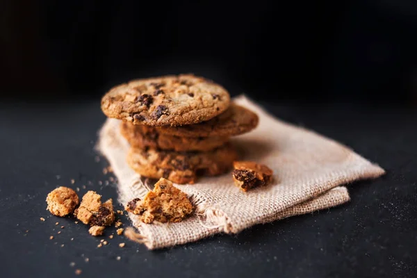 暗い背景のテキストとチョコレート チップ クッキーのヒープ ブラック スレート ボードのリネン ナプキン Copyspace と選択と集中のチョコ クッキー — ストック写真