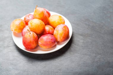 Üzerinde gri Taş Masa üstü olgun sarı Erik görüntüleyin. Taze plumps kopya spac ile