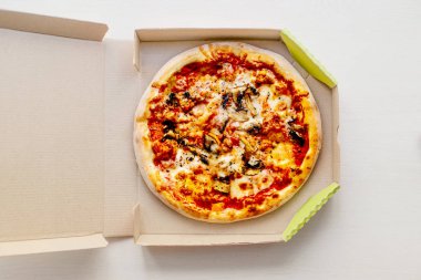 Bir karton kutu biber, domates, peynir ve domates sosu ile parlak arka plan üzerinde pizza. Pizzacı, menü.