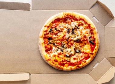 Bir karton kutu biber, domates, peynir ve domates sosu ile parlak arka plan üzerinde pizza. Pizzacı, menü.