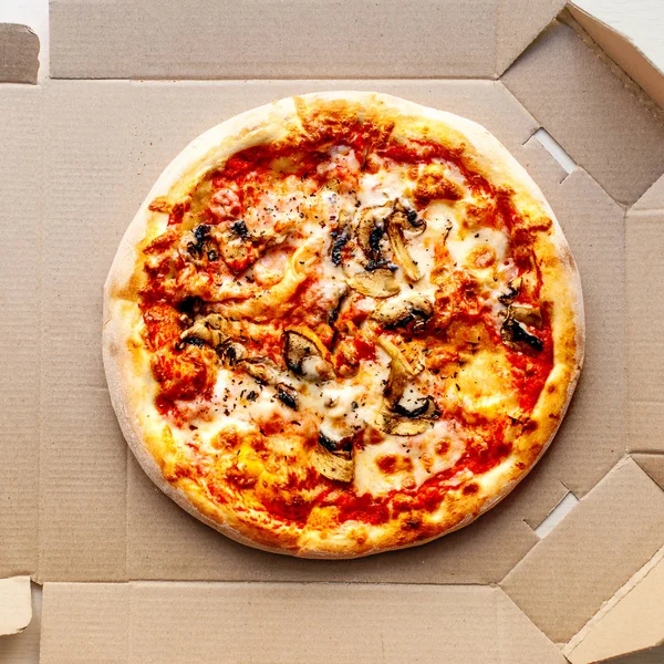 Pizza in a cardboard box on bright background with pepperoni, cherry tomatoes, cheese and tomato sauce. Pizza delivery, menu. — Stock Image Pizza Cardboard Box Bright Background Pepperoni Cherry Tomatoes Cheese Tomato Stock Picture