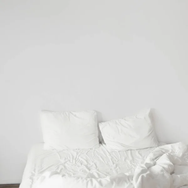 White bedroom with white pillows and white walls. Modern interior desig