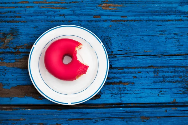 Donut Mordu Sur Une Assiette Sur Fond Bois Bleu Coloré — Photo