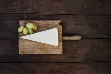 Brie peyniri koyu ahşap arka plan üzerinde dilim. Üstten Görünüm. Boşaltmak