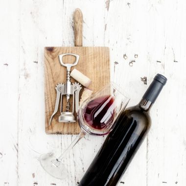  Bir bardak kırmızı şarap, şişe, tirbuşon ve Beyaz ahşap masa, copyspsce üzerinde rustik gemide şarap mantarlar. Şarap tadımı kavramı