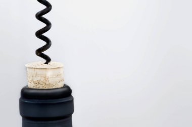 Bir şişe veya kırmızı şarap ile siyah tirbuşon üzerinde parlak gri açılış copespace ile arka plan bulanık. Şarap tadım kavramı 