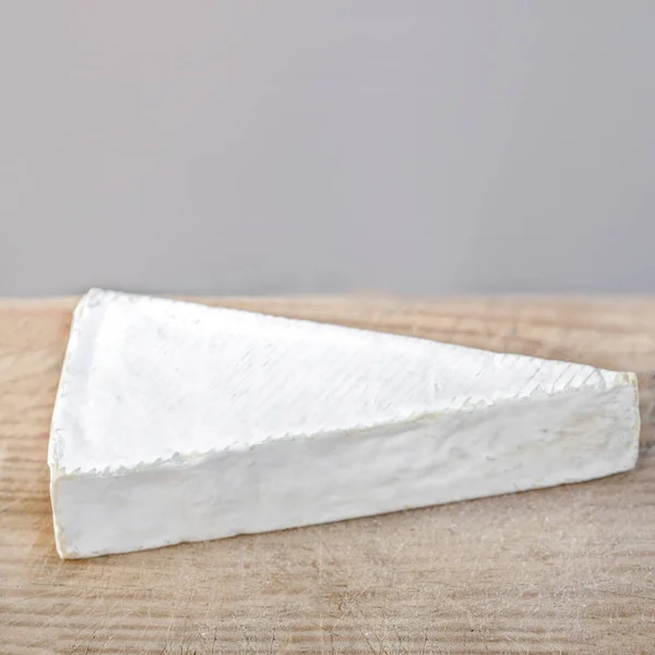素朴な白い木製 Backeround のブリーチーズのウェッジ フランスの地域から柔らかい牛の乳のチーズを白します 平面図です コピー スペース — ストック写真