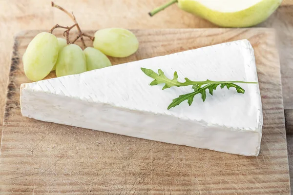 ブドウや果物 まな板の上の新鮮なブリーチーズ平面図です 白い素朴な木製の背景にブリーチーズ カマンベール チーズ — ストック写真
