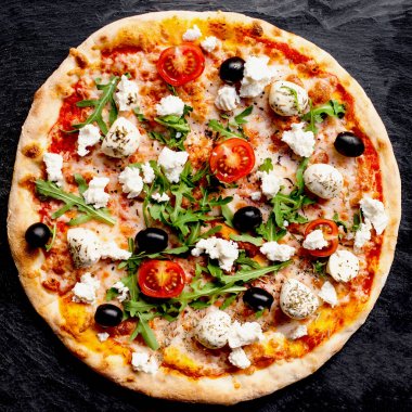Pizza domates, mozzarella peynir ve roka ile. Pizza menü. Karanlık taş tablo kopya alanı ile Üstten Görünüm