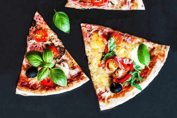 Pizza Margarita with tomatoes, basil, champignon mushrooms and cheese. Margherita Pizza on black stone background