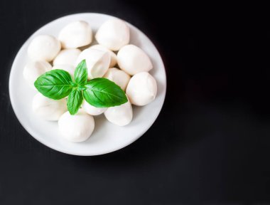 Taze kiraz domates, fesleğen yaprağı, mozzarella peyniri ile boşaltmak siyah arduvaz taş kara tahta üzerinde. Sağlıklı İtalyan geleneksel caprese salatası malzemeler. Organik Akdeniz gıda kavramı, düz yatıyordu