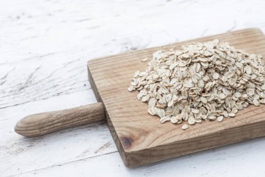 Yulaf ezmesi ya da yulaf gevreği ahşap tahta üzerinde. Granola, tahıl veya beyaz tahta eski masada haddelenmiş yulaf. Sağlıklı Kahvaltı, kopya alanı