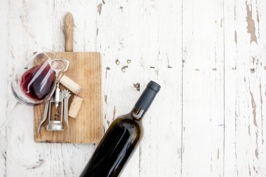  Bir bardak kırmızı şarap, şişe, tirbuşon 