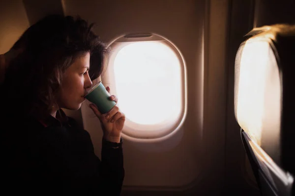 비행기 안에서 커피를 마시는 여자 — 스톡 사진