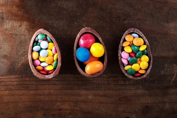 Ovos Páscoa Chocolate Fundo Madeira Escura Com Doces Pequenos Coloridos — Fotografia de Stock