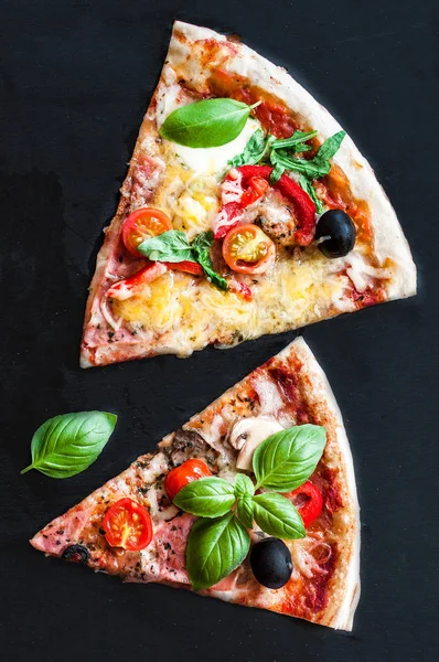 Pieces of pizza Margarita with tomatoes, basil, champignon mushrooms and cheese