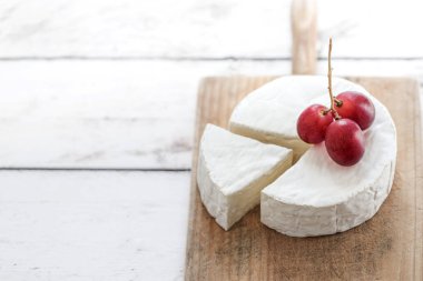 Peynir parçası ile yumuşak peynir direksiyonda ahşap tahta üzüm ile
