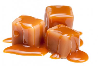 Caramel candies with caramel sauce isolated on white background clipart