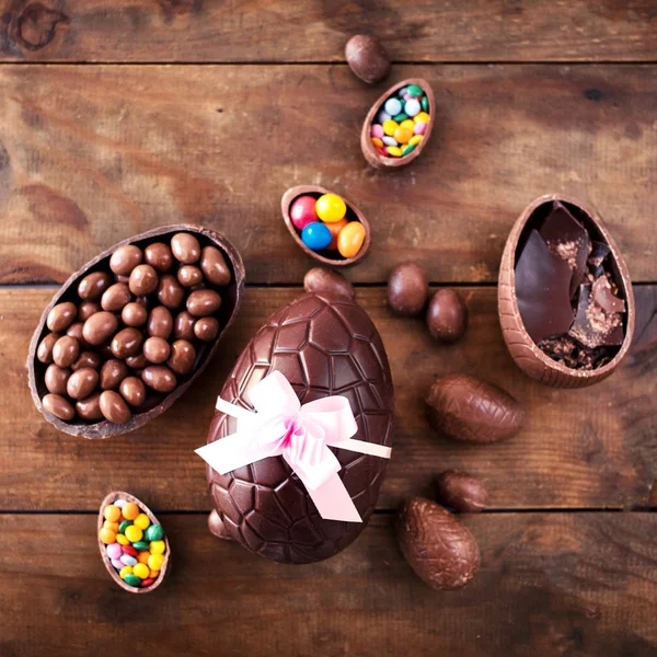 Čokoládová Velikonoční Vejce Dřevěné Pozadí Stuhou Luk Bonbóny — Stock fotografie