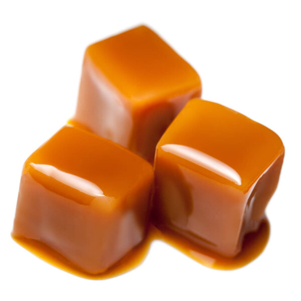 Карамельные конфеты с карамельным соусом на белом фоне
