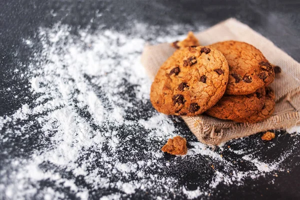 黒いテーブル表面のリネン ナプキンにチョコレート クッキー — ストック写真