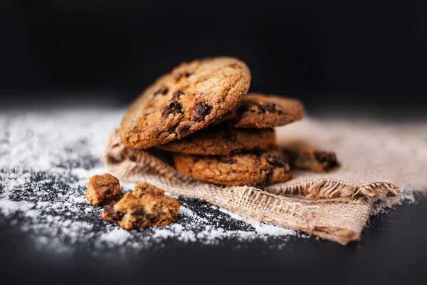 黒いテーブル表面のリネン ナプキンにチョコレート クッキー — ストック写真