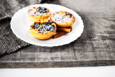 cassia-kabuk üzerinde eski püskü tablo ile geleneksel Portekiz tatlı yumurta tartları servis