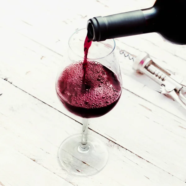 Gieten van rode wijn uit fles — Stockfoto