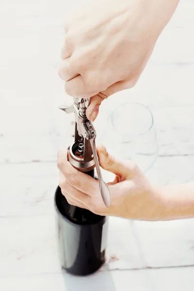 Kobieta otwarcia butelki czerwonego wina — Zdjęcie stockowe