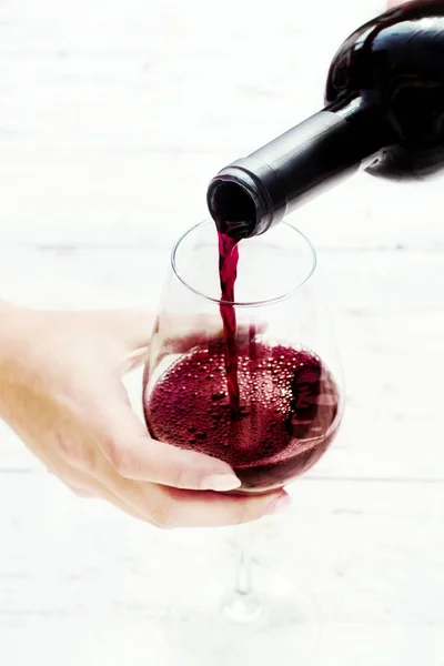 Female hand Pouring red  wine