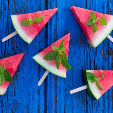 Karpuz Meyve dilimleri ile nane yaprakları üzerinde mavi rustik ahşap arka plan
