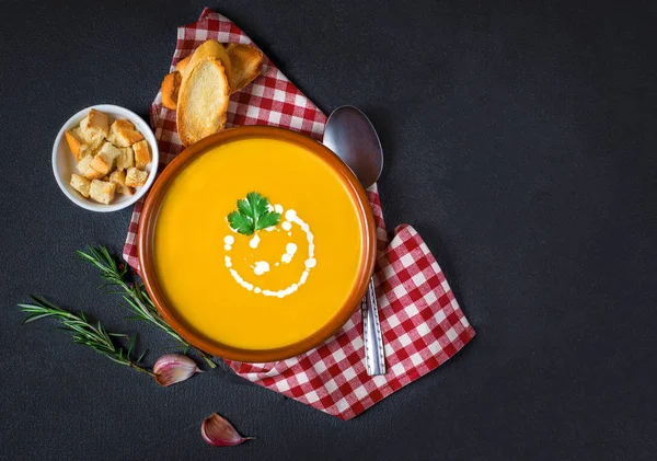 Cream soup with pumpkin and carrot on red classic checkered tablecloth on wooden rustic table — Stock Image Cream Soup Pumpkin Carrot Red Classic Checkered Tablecloth Wooden Rustic Royalty Free Stock Images