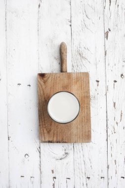 Süt beyaz rustik ahşap zemin üzerinde kesme tahtası üzerinde