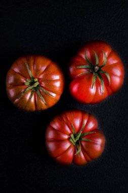 Siyah taş zemin üzerine olgun taze domates 