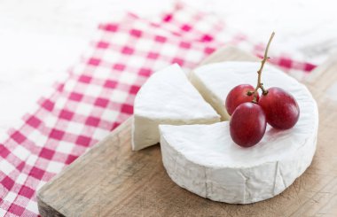 Peynir parçası ile yumuşak peynir direksiyonda ahşap tahta üzüm ile