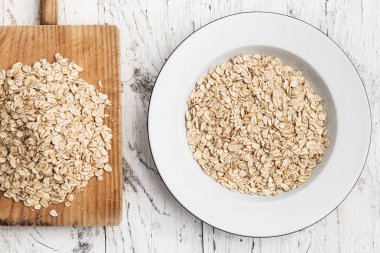 Haddelenmiş yulaf kase ve doğrama kurulu beyaz tahta masada Üstten Görünüm