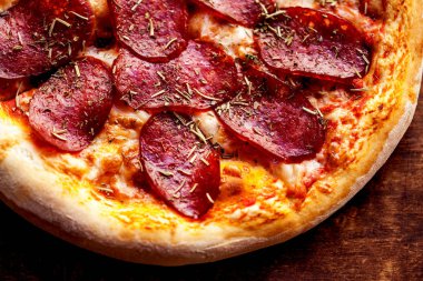 Biberli ve eritme peynir rustik ahşap masa üzerinde sıcak pizza