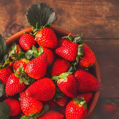 Yığın kopya alanı ile ahşap masa üzerinde kase taze çilek.