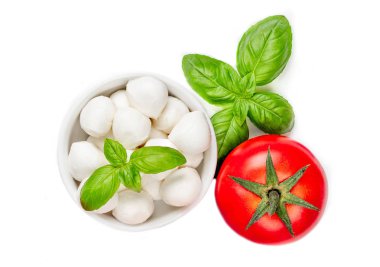 Mozzarella peyniri, domates ve fesleğen beyaz zemin üzerine taze salata malzemelerle.
