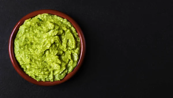 Μεξικάνικο Guacamole Στην Πήλινη Κούπα Μαύρο Φόντο — Φωτογραφία Αρχείου