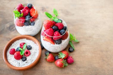 Chia puding ve çilek ahşap rustik arka plan üzerine gözlük ile yoğurt