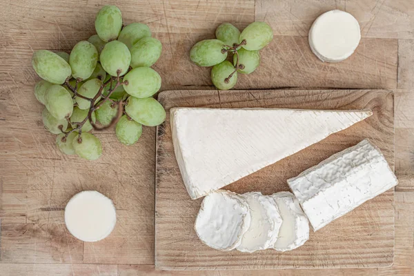 Queso fresco con frutas sobre tabla de madera sobre fondo blanco . —  Fotos de Stock