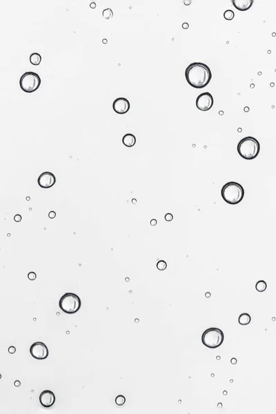 A água da chuva cai na janela clara. Padrão natural de gotas de chuva — Fotografia de Stock