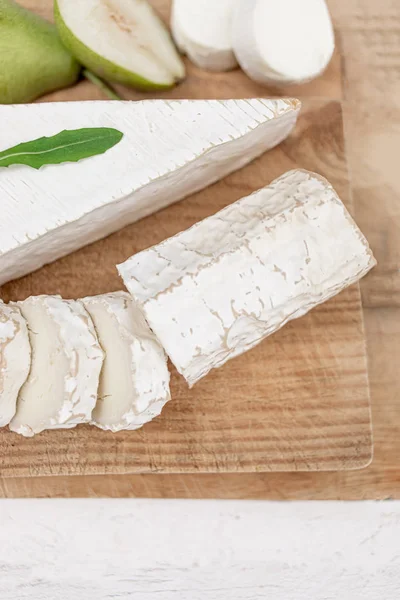 Fresh cheese on Wooden board over white background. Cheese platter