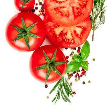 Domates, otlar ve baharatlardan oluşan yaratıcı bir düzen. Beyaz arka planda izole edilmiş kırmızı domates ve fesleğen yaprakları. Düz yatıyordu. Üst görünüm