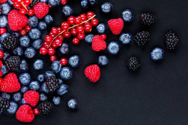 Siyah taş arka planda çeşitli taze orman böğürtlenleri, üst manzara. Böğürtlen. Düz yatıyordu. Kopyalama alanı