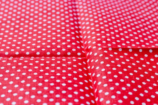 Polka dot on red canvas cotton texture. Red fabric with printed white circles. Bright colored cotton background. Selective focus